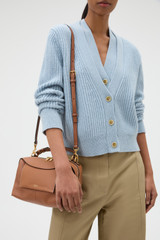Profile view of model wearing the Oroton Mica Bowler in Brandy and Premium pebble grain leather for Women .