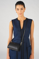 Profile view of model wearing the Oroton Harvey Baguette Crossbody in Black and Smooth leather for Women .