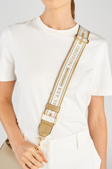 Profile view of model wearing the Oroton Heather Long Light Gold Webbing Strap in Mushroom/Cream and 100% polyester material for Women .