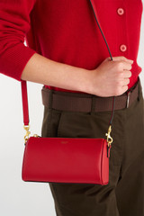 Profile view of model wearing the Oroton Harvey Baguette Crossbody in DARK RUBY and Premium smooth leather for Women .