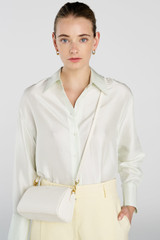 Profile view of model wearing the Oroton Harvey Baguette Crossbody in Cream and Premium smooth leather for Women .