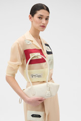 Profile view of model wearing the Oroton Breeze Baguette in Clotted Cream and Premium smooth leather for Women .