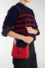 Profile view of model wearing the Oroton Dylan Mini Baguette Crossbody in DARK RUBY and Premium pebble leather for Women .
