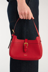 Profile view of model wearing the Oroton Dylan Mini Baguette Crossbody in DARK RUBY and Premium pebble leather for Women . IP:2