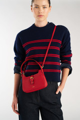 Profile view of model wearing the Oroton Dylan Mini Baguette Crossbody in DARK RUBY and Premium pebble leather for Women . IP:3