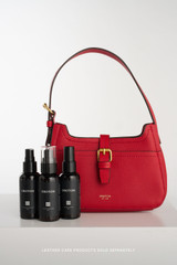 Profile view of model wearing the Oroton Dylan Mini Baguette Crossbody in DARK RUBY and Premium pebble leather for Women .