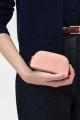 Profile view of model wearing the Oroton Eve Mini Beauty Case in BLOSSOM and Premium pebble leather for Women .