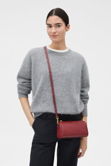 Profile view of model wearing the Oroton Harvey Baguette Crossbody in BERRY and Premium smooth leather for Women .