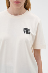 Profile view of model wearing the Oroton Maggie Graphic Tee in Calico and 100% cotton single jersey fabric for Women .
