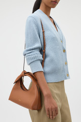 Profile view of model wearing the Oroton Myrtle Mini Bag in Cognac and Premium smooth leather for Women .