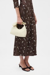 Profile view of model wearing the Oroton Myrtle Mini Bag in Vanilla Bean and Premium smooth leather for Women .