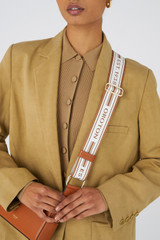 Profile view of model wearing the Oroton Heather Long Light Gold Webbing Strap in Cognac/Natural and Polyester webbing strap for Women .