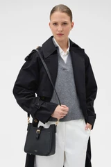 Profile view of model wearing the Oroton Dylan Small Bucket in Black and Premium pebble leather for Women .