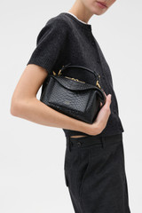 Profile view of model wearing the Oroton Mica Texture Mini Bowler in Black Snake and Premium textured leather for Women .