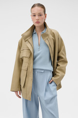 Profile view of model wearing the Oroton Utility Parka in Haystack and 100% cotton fabric for Women .