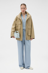 Profile view of model wearing the Oroton Utility Parka in Haystack and 100% cotton fabric for Women .