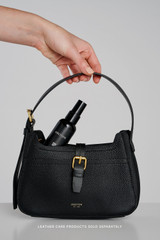 Profile view of model wearing the Oroton Dylan Mini Baguette Crossbody in Black and Premium pebble leather for Women .