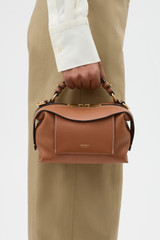 Profile view of model wearing the Oroton Mica Mini Bowler in Brandy and Premium pebble leather for Women .