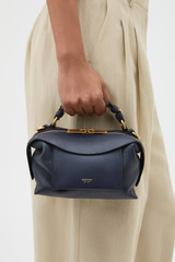Profile view of model wearing the Oroton Mica Mini Bowler in North Sea and Premium pebble leather for Women .