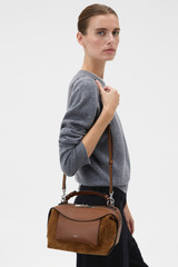 Profile view of model wearing the Oroton Mica Mini Bowler in Teak and Premium suede leather for Women .