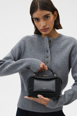 Profile view of model wearing the Oroton Mica Beaded Mini Bowler in Black and Premium canvas material for Women .