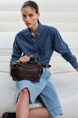Profile view of model wearing the Oroton Mica Bowler in Dark Chocolate and Premium pebble grain leather for Women .