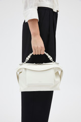 Profile view of model wearing the Oroton Mica Smooth Bowler in Warm White and Premium smooth leather for Women .