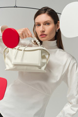 Profile view of model wearing the Oroton Mica Smooth Bowler in Warm White and Premium smooth leather for Women .