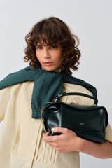 Profile view of model wearing the Oroton Mica Crackle Bowler in Shade Green and Premium crackle leather for Women .