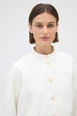 Profile view of model wearing the Oroton Curved Sleeve Jacket in Antique White and 100% cotton fabric for Women .