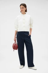 Profile view of model wearing the Oroton Curved Sleeve Jacket in Antique White and 100% cotton fabric for Women .