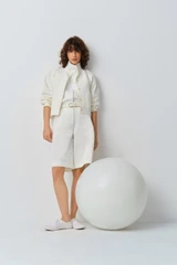 Profile view of model wearing the Oroton Curved Sleeve Jacket in Antique White and 100% cotton fabric for Women .