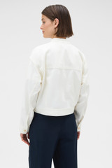 Profile view of model wearing the Oroton Curved Sleeve Jacket in Antique White and 100% cotton fabric for Women .