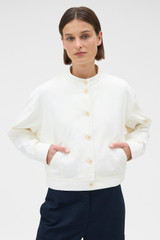 Profile view of model wearing the Oroton Curved Sleeve Jacket in Antique White and 100% cotton fabric for Women .