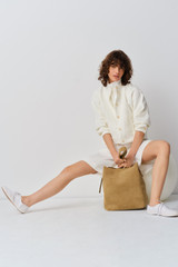 Profile view of model wearing the Oroton Curved Sleeve Jacket in Antique White and 100% cotton fabric for Women .