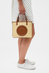 Profile view of model wearing the Oroton Polly Straw Small Tote in Natural/Cognac and Woven straw material for Women .