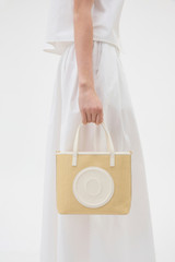 Profile view of model wearing the Oroton Polly Straw Small Tote in Natural/Cream and Woven straw material for Women . IP:2