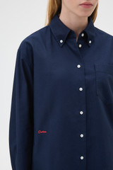 Profile view of model wearing the Oroton Oxford Shirt in North Sea and 100% cotton fabric for Women .