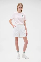 Profile view of model wearing the Oroton Flat Front Carpenter Short in Antique White and 100% cotton fabric for Women .