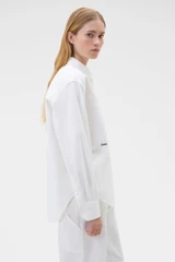 Profile view of model wearing the Oroton Oxford Shirt in Antique White and 100% cotton fabric for Women .