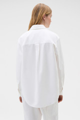 Profile view of model wearing the Oroton Oxford Shirt in Antique White and 100% cotton fabric for Women .