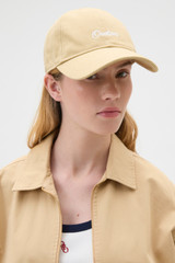 Profile view of model wearing the Oroton Oroton Script Cap in Praline and 100% cotton canvas fabric for Women . IP:2