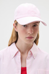 Profile view of model wearing the Oroton Oroton Script Cap in Perfect Pink and 100% cotton canvas fabric for Women .