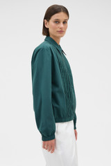 Profile view of model wearing the Oroton Pleated Bomber Shirt in Neptune Green and 100% cotton poplin fabric for Women .