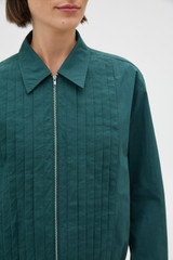 Profile view of model wearing the Oroton Pleated Bomber Shirt in Neptune Green and 100% cotton poplin fabric for Women .
