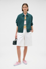 Profile view of model wearing the Oroton Pleated Bomber Shirt in Neptune Green and 100% cotton poplin fabric for Women .