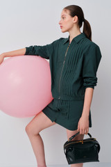 Profile view of model wearing the Oroton Pleated Bomber Shirt in Neptune Green and 100% cotton poplin fabric for Women .